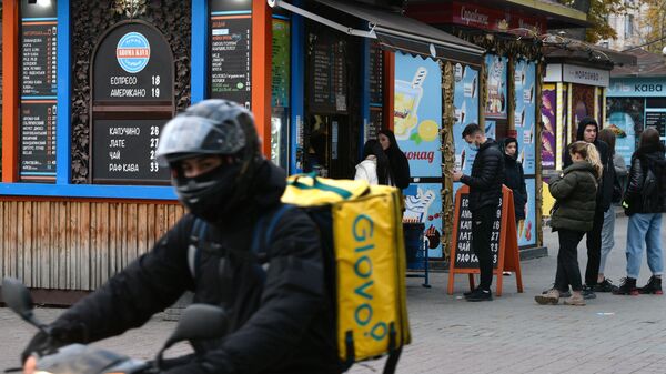 Курьер службы доставки на одной из улиц в Киеве. - Sputnik Узбекистан
