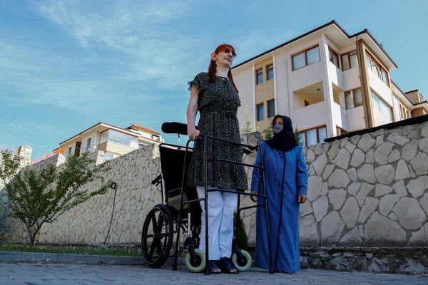 Самая высокая женщина в мире — 24-летняя Румейса Гельги, ее рост составляет 215,16 см. Она живет в Турции. На фото девушка — вместе со своей мамой Сафие Гельги на фоне их дома. 14 октября 2021 года. - Sputnik Узбекистан