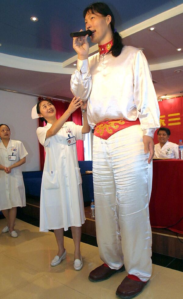 Самая высокая женщина в Азии, девушка из Китая Яо Дефэн ростом 2,3 метра благодарит врачей и медсестер в больнице Санджиу в Гуанчжоу 18 мая 2002 года, где она проходила курс лечения, чтобы остановить ее рост. - Sputnik Узбекистан