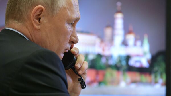  Президент России Владимир Путин во время разговора по телефону  - Sputnik Ўзбекистон