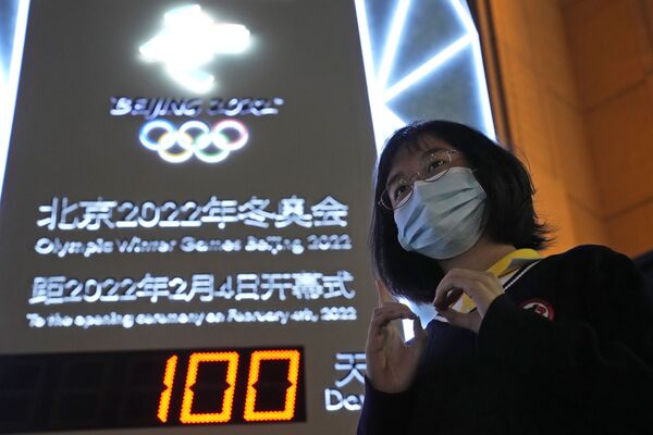 Болельщица на фоне табло с обратным отсчетом, которое показывает, что до зимней Олимпиады в Пекине осталось 100 дней. - Sputnik Узбекистан