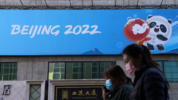 Люди напротив баннера Олимпийских игр в Пекине в Китае  - Sputnik Ўзбекистон