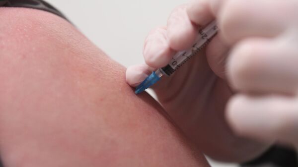 Медицинский работник делает инъекцию с вакциной Гам-Ковид-Вак (Спутник V) в пункте вакцинации от коронавируса COVID-19 на территории ТЦ Европейский в Москве. - Sputnik Узбекистан