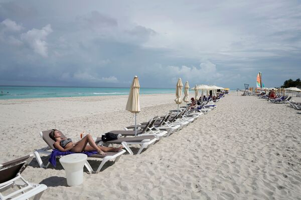 Турист, греющийся на солнечном пляже Кубы.  - Sputnik Узбекистан