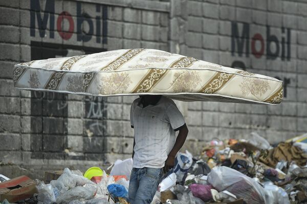 Мужчина перекидывает кровать через голову на Гаити. - Sputnik Узбекистан