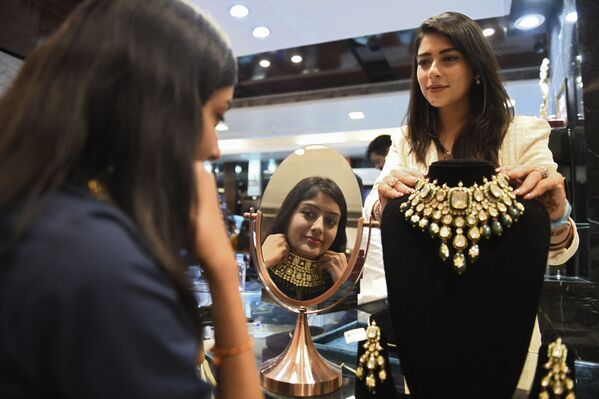 Девушка примеряет ожерелье в ювелирном магазине перед фестивалем Дивали в Индии. - Sputnik Узбекистан