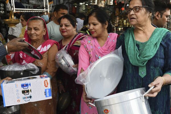 Индийцы покупают посуду на рынке в Амритсаре по случаю предстоящего празднования Дхантерас — первого дня фестиваля Дивали. - Sputnik Узбекистан