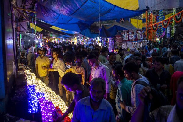 Жители Индии делают покупки в преддверии фестиваля огней Дивали. - Sputnik Узбекистан