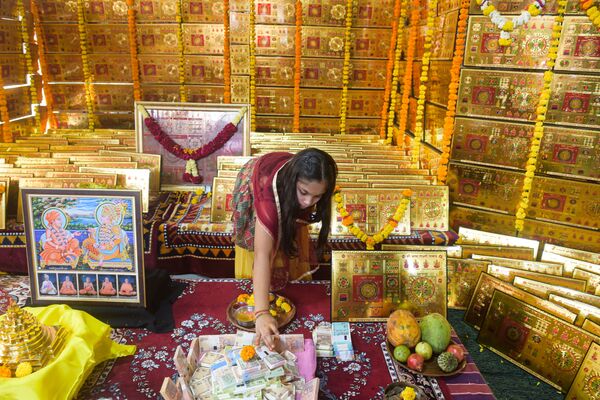 Индианка  участвует в ритуале в Дхарматма Кутир перед фестивалем огней в Ахмедабаде. - Sputnik Узбекистан