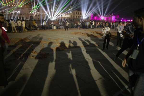 Тени людей, фотографирующих генеральную репетицию лазерного шоу перед праздником. - Sputnik Узбекистан
