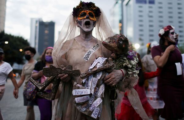Женщина принимает участие в &quot;Марше Катрины&quot; в знак протеста против убийства и насилия в отношении женщин в Мехико, 1 ноября. - Sputnik Узбекистан