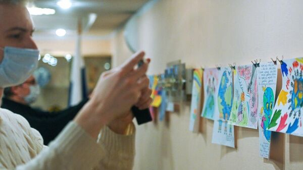 Посетитель выставки Дети рисуют МИР. Дети Донбасса детям Карабаха в Россотрудничестве - Sputnik Узбекистан