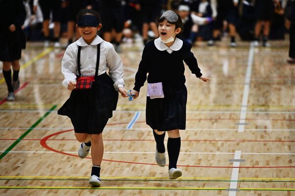 Ученики начальной школы Ариакэ-ниши Гакуэн принимают участие в упражнении под руководством параатлета Чиаки Такада (не на фото) во время мероприятия, приуроченного к Паралимпийским играм 2020 года в Токио, 25 февраля 2020 г. - Sputnik Узбекистан