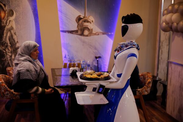 Роботы-официантки одеты в платье, шапочку и шарфик, а блюда приносят на специальном подносе. - Sputnik Узбекистан