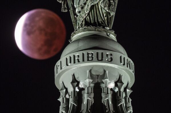 Кровавая луна на фоне надписи E Pluribus Unum, что в переводе с латинского означает &quot;Из многих - единое&quot;, на Статуе Свободы на вершине купола Капитолия в Вашингтоне, США. - Sputnik Узбекистан