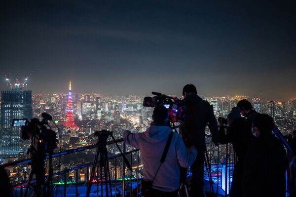 Журналисты снимают затмение со смотровой площадки в Токио. - Sputnik Узбекистан