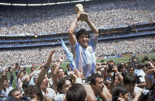 Диего Марадона держит кубок после решающей победы Аргентины над сборной Западной Германии со счетом 3:2 в финале чемпионата мира 1986 года в Мехико. - Sputnik Узбекистан