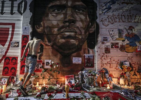 Импровизированный алтарь, созданный фанатами Диего Марадоны в день его смерти у стадиона в Буэнос-Айресе, названного в его честь. - Sputnik Узбекистан