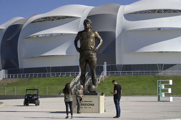 Люди фотографируются на фоне памятника Диего Марадоне перед стадионом  Estadio Unico Madre de Ciudades в Сантьяго-дель-Эстеро в Аргентине. - Sputnik Узбекистан