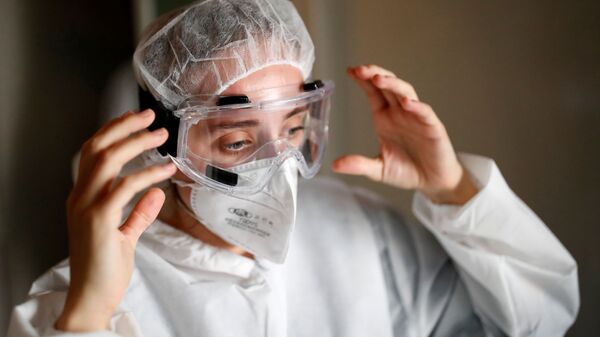 Медицинский работник в защитном костюме и маске в Нанте, Франция - Sputnik Ўзбекистон