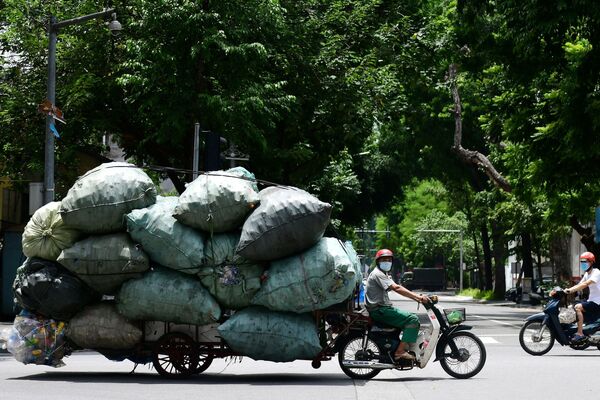 Старьевщик перевозит мешки с пластиковым мусором на мотоцикле с тележкой, 13 августа 2021 года. - Sputnik Узбекистан