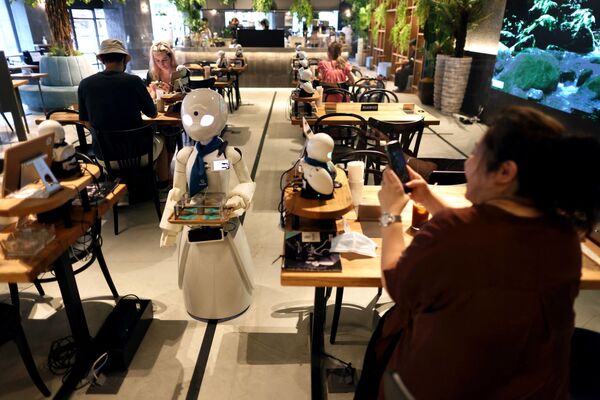 На этой фотографии, сделанной 17 августа 2021 года, робот-гуманоид разносит напитки в кафе в Токио. - Sputnik Узбекистан