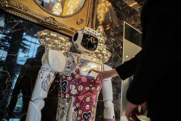 Работник отеля получает информацию у робота в холле отеля Sky в Сэндтоне, Южная Африка, 29 января 2021 г. - Sputnik Узбекистан