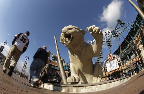 Болельщики проходят мимо скульптуры тигра перед матчем Американской лиги по бейсболу между Бостон Ред Сокс и Детройт Тайгерс 16 октября 2013 г, Детройт. - Sputnik Узбекистан