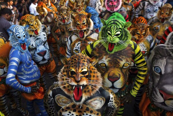 Актеры в масках и с раскрашенными телами танцуют &quot;Пуликали&quot; или Тигриный танец в Триссуре в индийском штате Керала, 19 сентября 2013 г.  Пуликали — танец-имитация охоты на тигра, традиционно исполняется во время ежегодного праздника урожая. - Sputnik Узбекистан