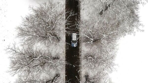 Автомобиль на дороге во время снегопада, иллюстративное фото - Sputnik Узбекистан