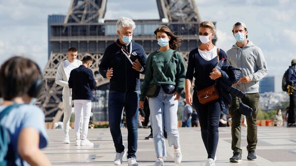 Прохожие в защитных медицинских масках у Эйфелевой башни в Париже, Франция - Sputnik Узбекистан