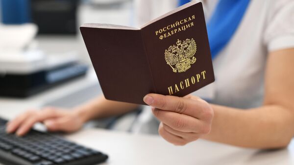 Sotrudnik PFR derjit v rukax pasport RF. - Sputnik Oʻzbekiston
