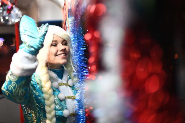 Снегурочка в салоне новогоднего трамвая, украшенного яркими светодиодными огнями, в Москве. - Sputnik Узбекистан