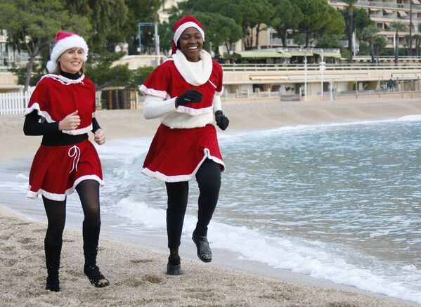 Люди в рождественских костюмах перед купанием в Средиземном море — рождественской традицией в пользу детей-жертв цунами в Монако 20 декабря 2009 г. - Sputnik Узбекистан