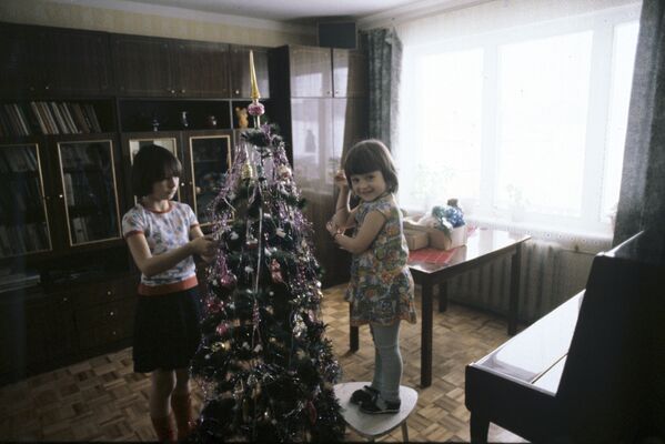 Дети наряжают новогоднюю елку, 1983 год. Многие, кто вырос в те годы, хранят новогодние игрушки из детства и даже вешают их теперь на елку. - Sputnik Узбекистан