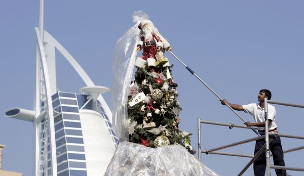 Мужчина открывает большую рождественскую ёлку в Дубае 10 декабря 2006 г. - Sputnik Узбекистан