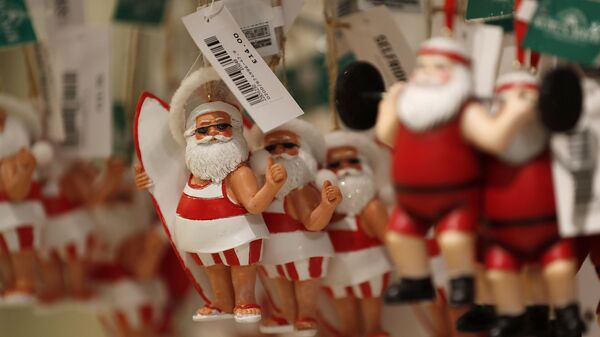 Елочные игрушки в виде Санта-Клауса в шортах в Лондоне  - Sputnik Узбекистан