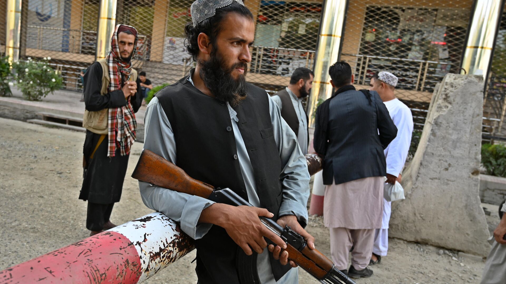Боец Талибана* стоит у шлагбаума  - Sputnik Узбекистан, 1920, 07.02.2022