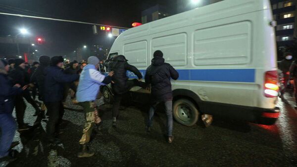 Митингующие в Алматы нападают на полицейский автомобиль - Sputnik Ўзбекистон