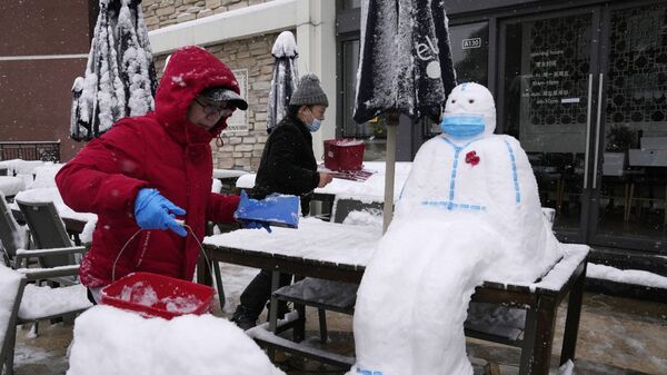 Работники ресторане лепят снеговика в форме медицинского работника в защитном костюме и маске в Пекине, Китай - Sputnik Узбекистан