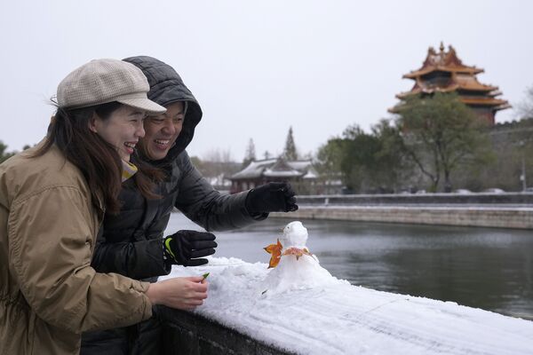 Пара лепит снеговика возле Запретного города в Пекине, Китай. - Sputnik Узбекистан