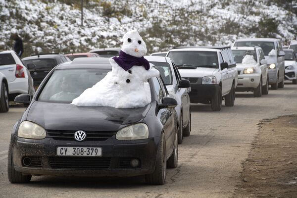 Снеговик-экстремал на капоте машины в горах близ города Сирес в ЮАР. - Sputnik Узбекистан