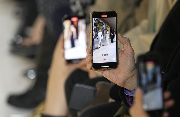 Зрители снимают фото и видео на телефоны во время показа модной коллекции Dior Haute Couture на Неделе моды в Париже, 24 января 2022 года. - Sputnik Узбекистан