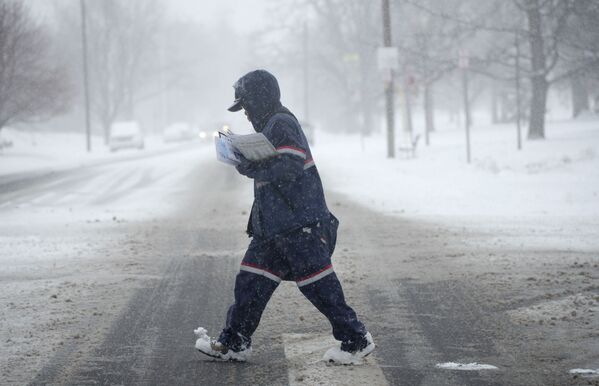 Почтальон доставляет корреспонденцию во время снегопада в Денвере, США, 25 января 2022 г.  - Sputnik Узбекистан