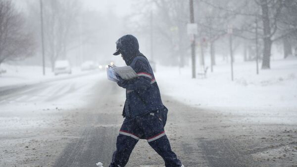 Мужчина во время снегопада на улице Денвера, США - Sputnik Узбекистан
