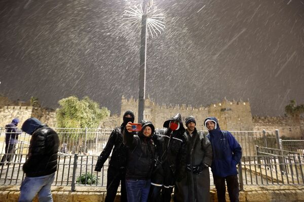 Люди делают селфи на фоне снегопада в Старом городе Иерусалима, 26 января 2022 г.  - Sputnik Узбекистан