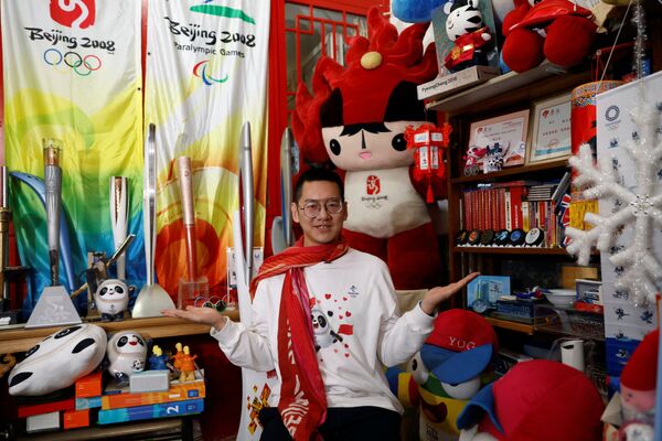 Чжан Вэньцюань, 35-летний олимпийский фанат, позирует со своей коллекцией олимпийских памятных вещей у себя дома в преддверии зимних Олимпийских игр 2022 года в Пекине, Китай, 22 января 2022 года. - Sputnik Узбекистан