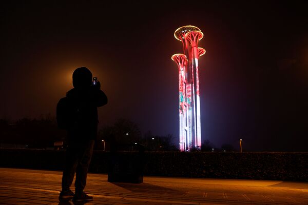 Человек фотографирует Олимпийскую башню перед зимними Олимпийскими играми 2022 года в Пекине. - Sputnik Узбекистан