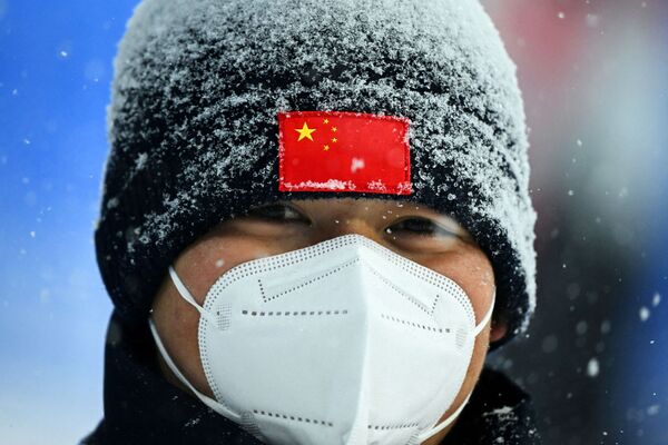 Пекинский полицейский стоит на страже одного из олимпийских объектов во время снежной бури. - Sputnik Узбекистан