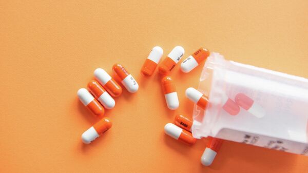 Prescription drugs on an orange background with a pill bottle - Sputnik Узбекистан